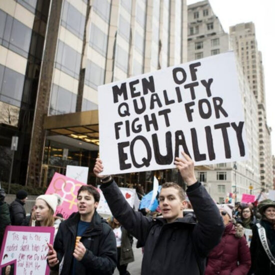 protesters with a sign that reads "men of quality fight for equality"