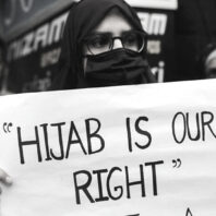 Woman holding protest sign reading 