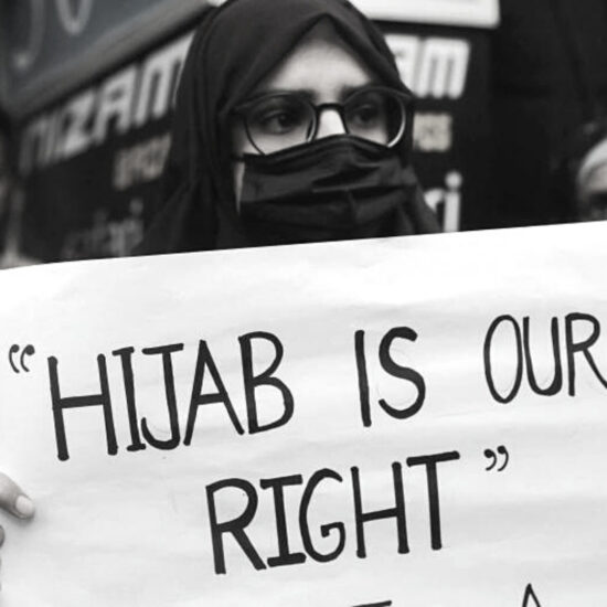 Woman holding protest sign reading "Hijab is our right"